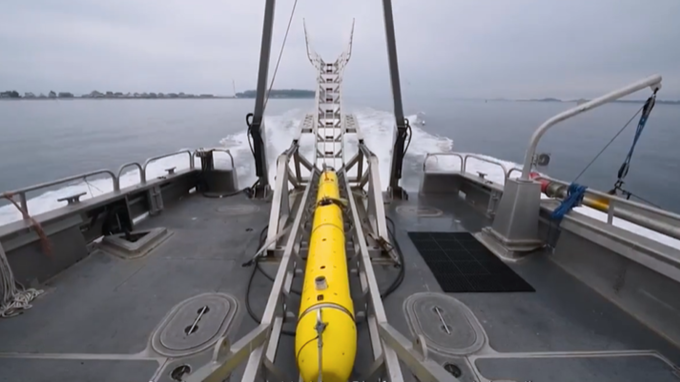 Unmanned underwater vehicle being deployed from naval vessel for AI-powered maritime operations