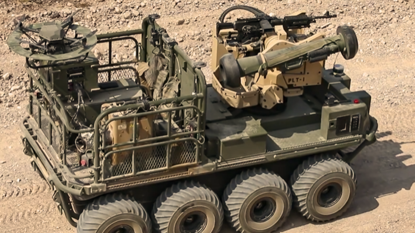 An autonomous multi-wheeled military ground vehicle equipped with mounted weapons and sensors, designed for unmanned combat operations in a rugged desert environment.