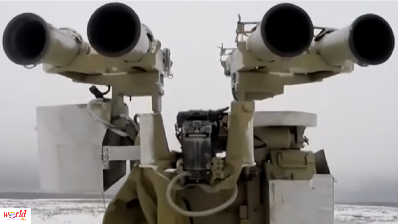 Close-up of a military launcher system with twin missile tubes mounted on a platform in an outdoor environment.