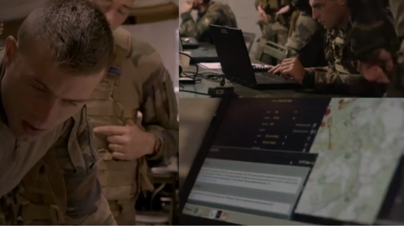 Military personnel using laptops and digital maps in a command center for real-time battle management.