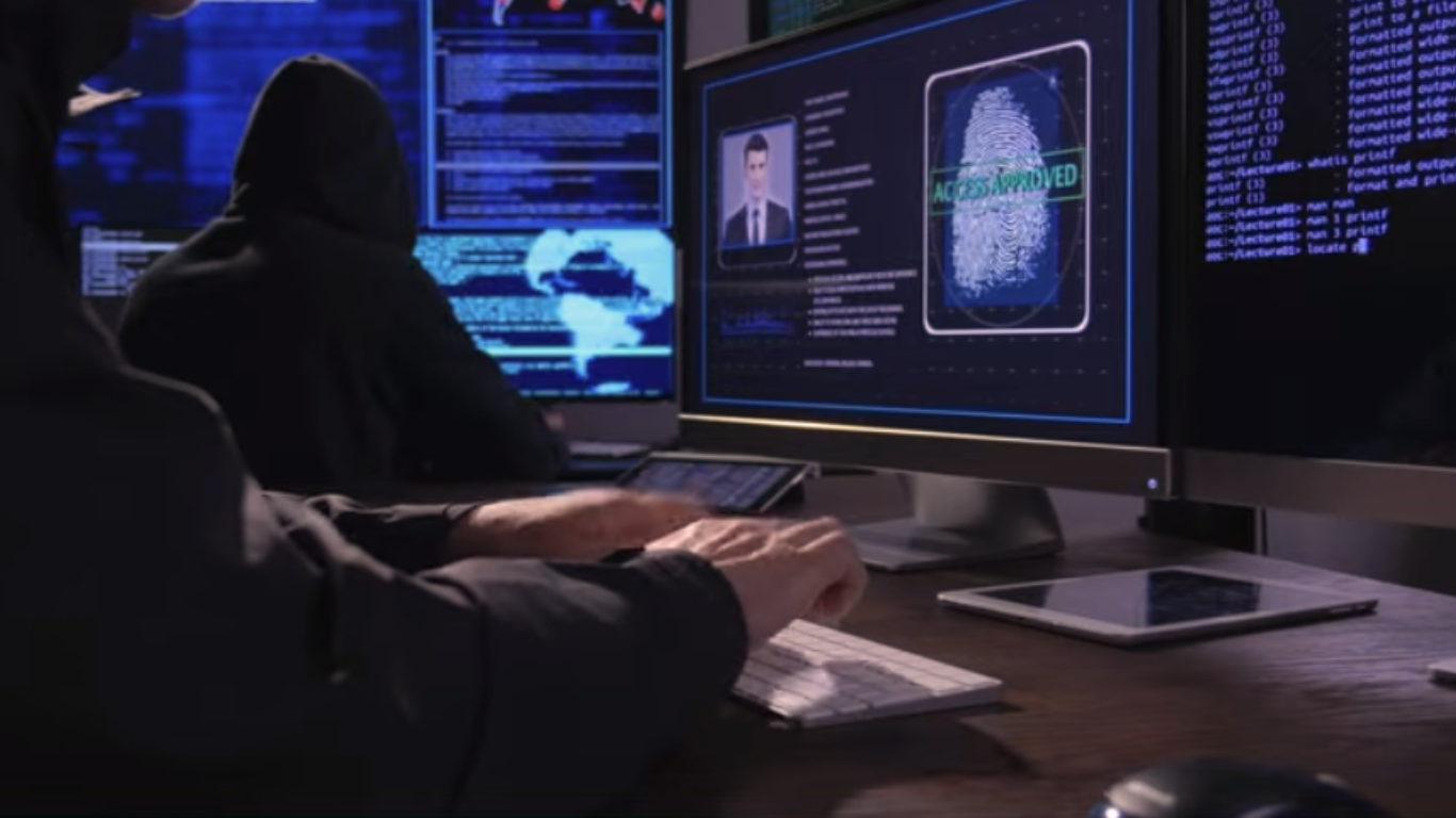 Two individuals in a dark room working on computers displaying code, a fingerprint scan labeled “Access Approved,” and global cyber data, representing advanced hacking operations.