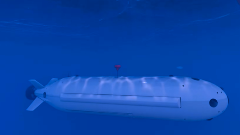 Autonomous underwater vehicle cruising beneath the ocean surface in deep blue water.