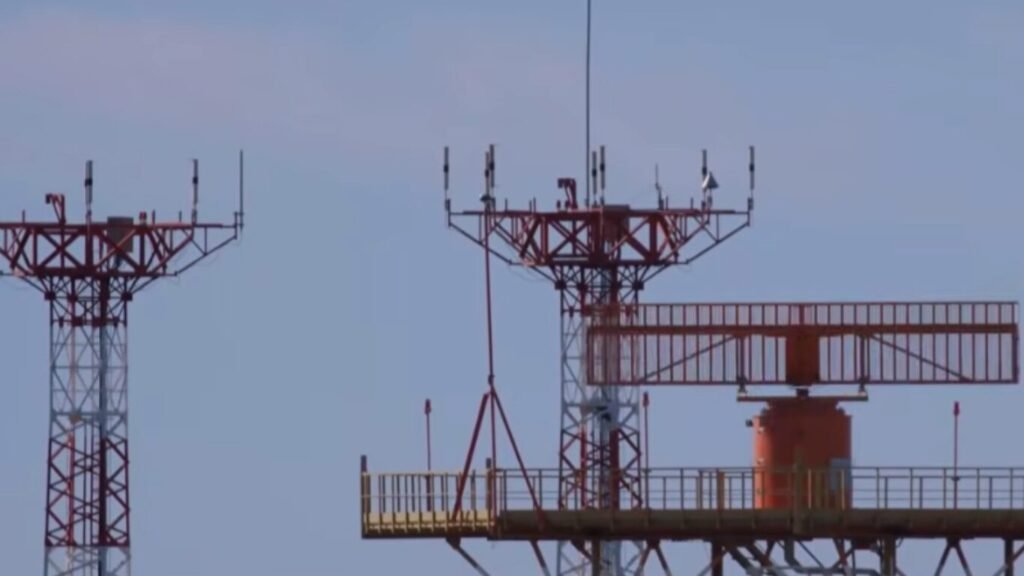 An airport radar system and communication tower array under a blue sky, referencing tracking developments for AI in Stealth Technology.