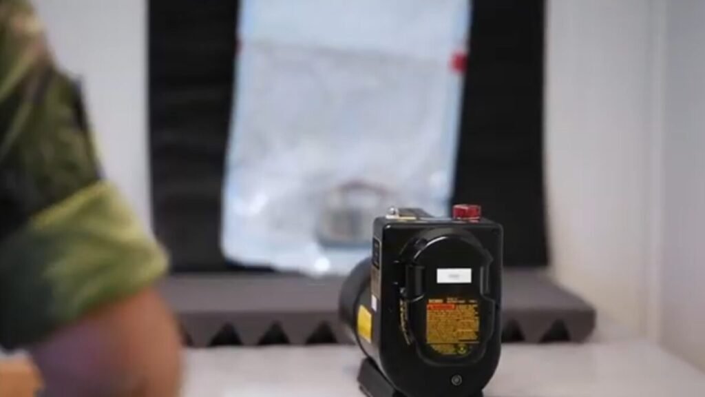 A military operator setting up a portable scanning device inside a test room, demonstrating hardware deployment for Biometric IFF authentication systems.