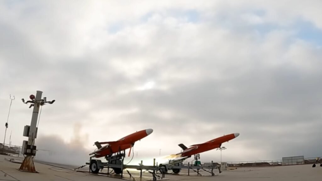 An orange jet-powered drone launching from a trailer under an overcast sky, demonstrating technology for Manned Unmanned Teaming.