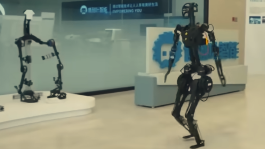 A slender black bipedal robot walking through a showroom floor, demonstrating agility frameworks relevant to advanced Military Robotics development.