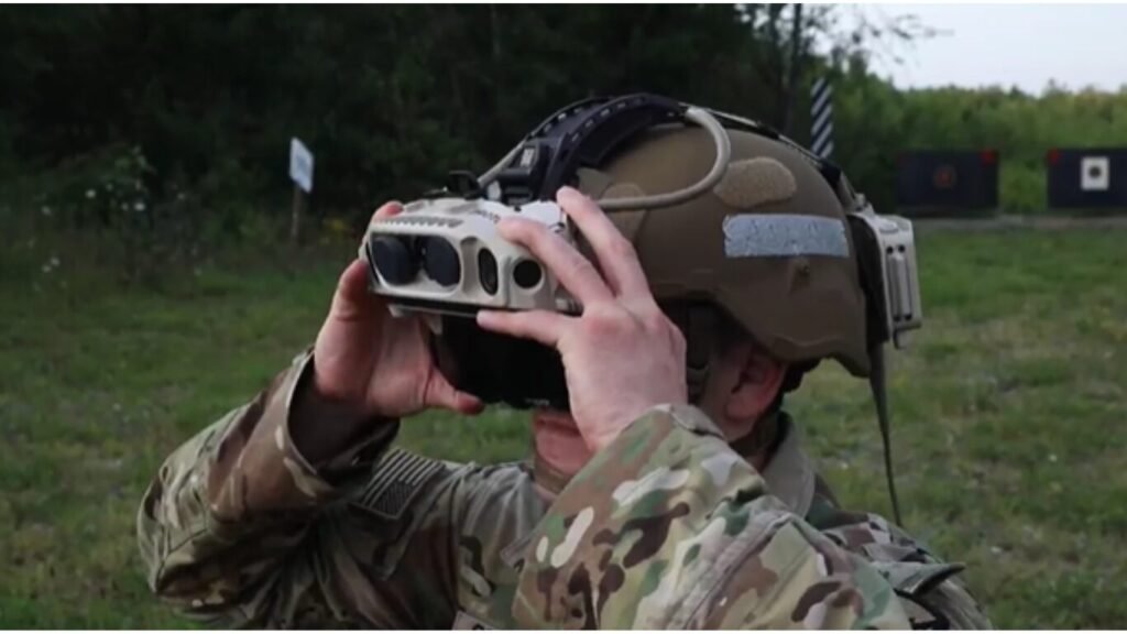 A soldier adjusting an IVAS mixed-reality headset mounted to a ballistic helmet, demonstrating how Neural Link Squad Coordination is changing the way military teams work.