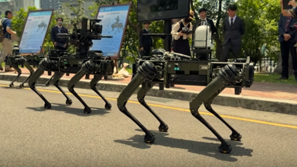 A row of dark green quadrupedal robotic dogs demonstrating mobility on a paved street, representing the tactical deployment of Q-UGVs in Urban Warfare.