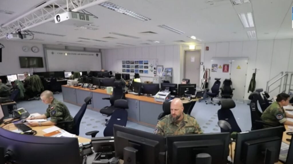 Military personnel in camouflage uniforms monitoring computer screens inside a modern command and control center, showcasing Tactical AI in Defence Operations.
