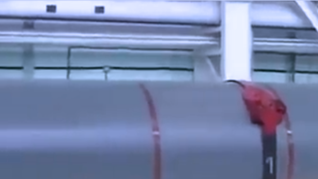 A close-up view of a sleek, gray hull belonging to advanced Underwater Unmanned Vehicles featuring a distinctive red sensor housing and a vertical numbered label.