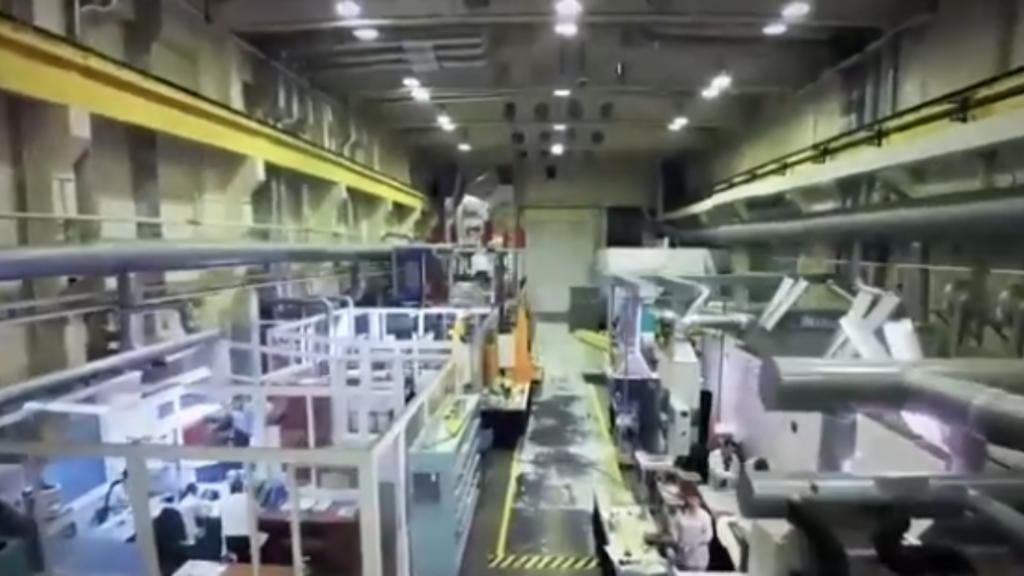 An overhead view of a large industrial manufacturing lab and cleanroom facility where technical teams develop and test components for Autonomous Satellite Guarding Systems.