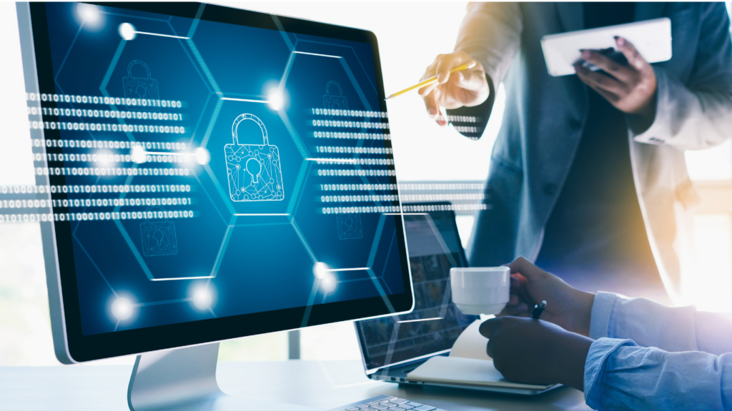 A computer monitor displaying a digital padlock icon and lines of binary code as professionals point to the screen, highlighting why privacy and data protection require serious attention when deploying Edge AI Hardware for Enterprise Applications.